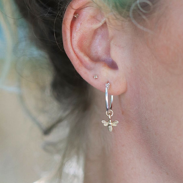 Pom Boutique Silver Hoop Earrings with Gold Bumble Bee Charms on Ear